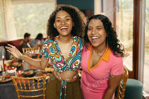 Preview: Happy female friends looking at camera with smile during festive home party