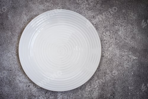 Preview: Empty white ceramic plate On a concrete background. Top view wit