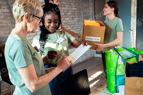 Preview: Group of volunteers with working in community charity donation center.