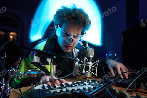 Preview: Angry guy plays music with midi keyboard sitting at table in room