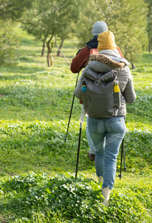 Preview: Hikers walking in nature with backpacks and trekking poles enjoying outdoor activity