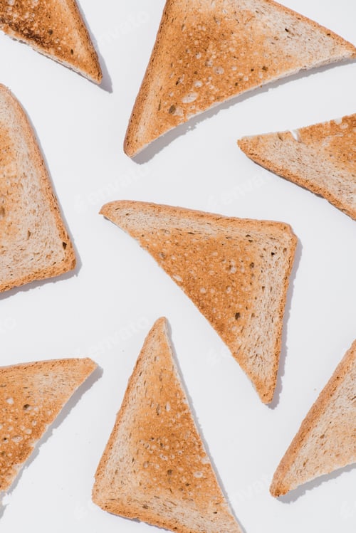 Preview: top view of toasts cut in triangles on white surface