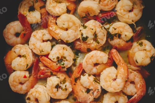 Preview: Baby shrimps with parsley and garlic are cooked in a pan, top view, flat lay, close-up