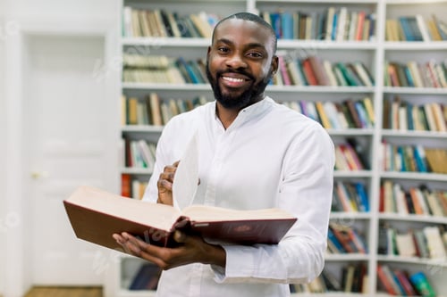 Preview: Smiling joyful male african american university student standing in modern reading hall of college