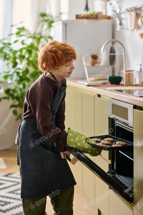 Preview: Joyful little boy baking cookies in a bright kitchen filled with warmth and happiness