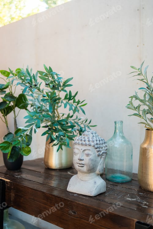 Preview: Buddha head with incense and plants in vase. Buddhism religion. Decorative Buddha statue on wooden t