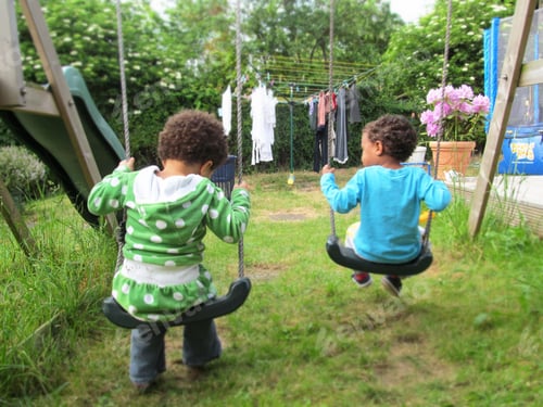 Preview: Two kids on a swing in a garden