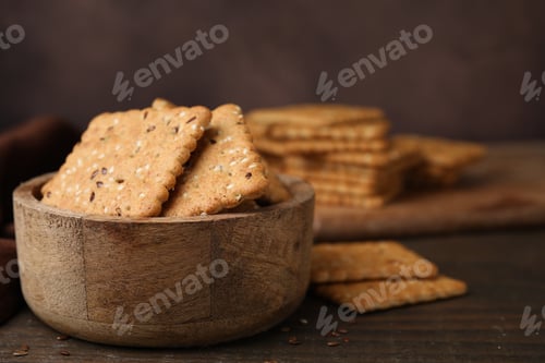 Preview: Cereal crackers with flax and sesame seeds in bowl on wooden table, closeup. Space for text