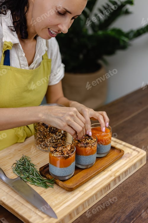 Preview: Woman with colorful healthy sweet deserts chia puddings made of almond milk, blue spirulina