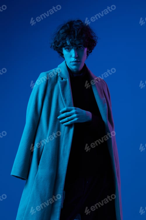 Preview: Man fashion in coat on dark blue background, neon light, style and trends, mixed light, men's