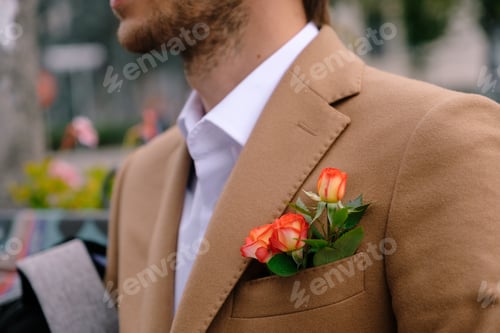 Preview: Close-up man dressed in classy jaket with three roses in poket