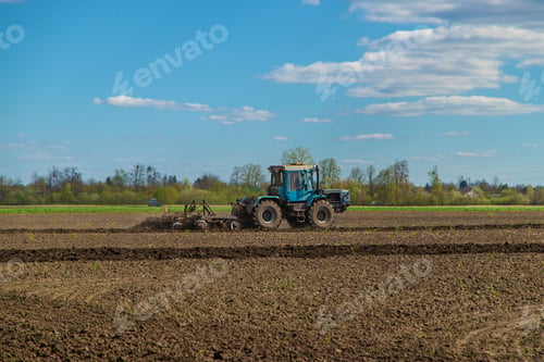 Preview: The tractor plows the soil in the field. Selective focus.