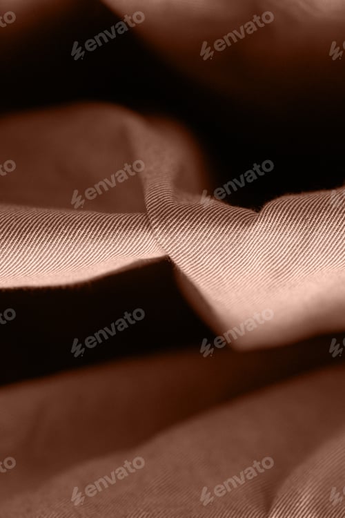 Preview: Close up of smooth brown textured cotton fabric with soft folds and light shadow