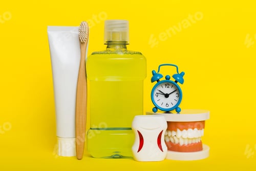 Preview: Mouthwash and other oral hygiene products on colored table top view with copy space.