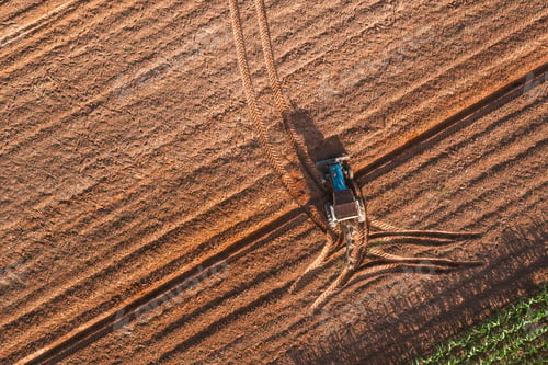 Preview: Aerial top view tractor plowing a field , preparing the land for a wheat planting operation.