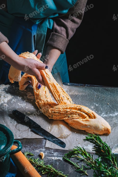 Preview: Woman is preparing homemade bitten fresh herb bread rolls of Provencal herbs with salt and garlic