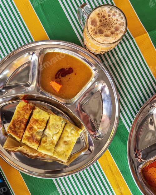 Preview: Roti Parata or Roti canai with curry sauce - popular Malaysian breakfast. Top view.