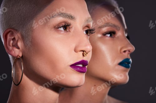 Preview: Studio shot of two beautiful young woman posing against a dark background