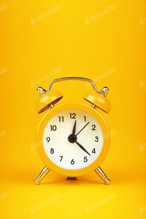 Preview: Close up one yellow alarm clock over warm yellow