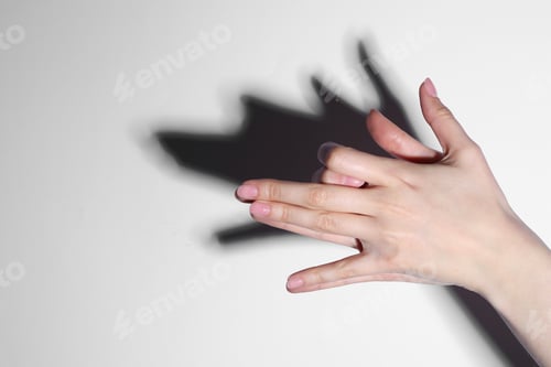 Preview: Shadow puppet. Woman making hand gesture like dog on light background, closeup. Space for text