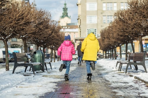 Preview: Children run down the street in winter jackets and warm hats. Friends jump and play.