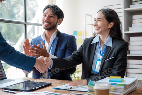 Preview: Young business people shaking hands in the office. Finishing successful meeting. Three persons