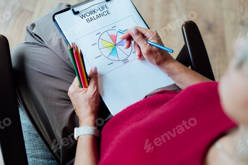 Preview: Woman drawing work-life balance wheel sitting on armchair at cozy home interior. Self-reflection