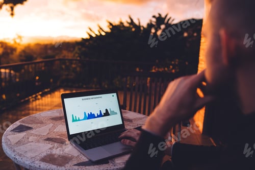 Preview: Faceless man working on laptop on terrace