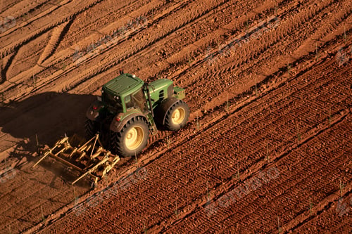 Preview: aerial view of Tractor Cultivating Straight Rows in Red Agricultural Field