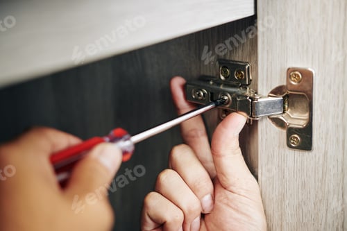 Preview: Man screwing door hinge