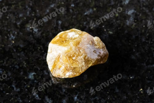 Preview: rough single grossular garnet crystal on black