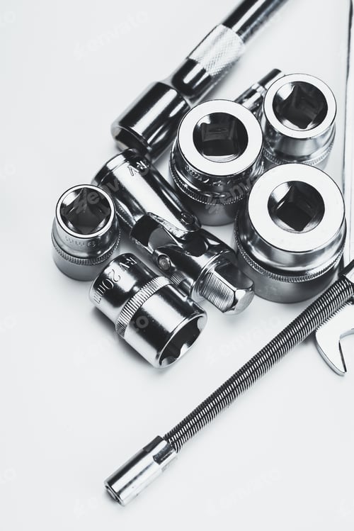 Preview: Collection of various metallic tools arranged on a flat surface showcasing their intricate details