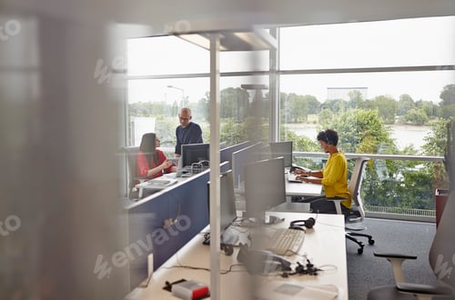 Visualização: Mulher com fone de ouvido trabalhando no escritório de plano aberto