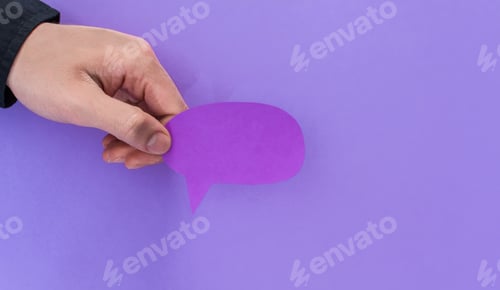 Preview: Male hand holding a speech balloon shape card on a purple background