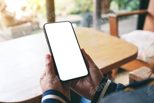 Preview: Mockup image of hands holding black mobile phone with blank desktop screen