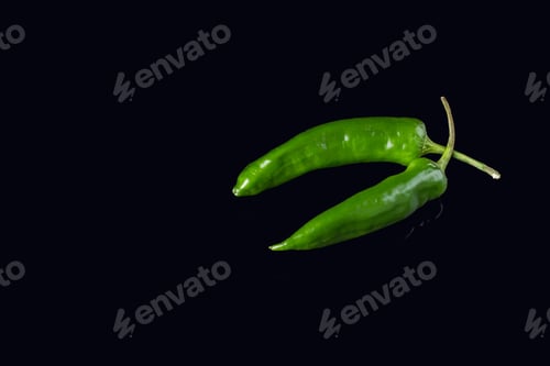 Preview: Green chili peppers on black background.