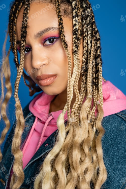 Preview: beautiful african american woman in pink hoodie and denim vest looking at camera, dark skinned