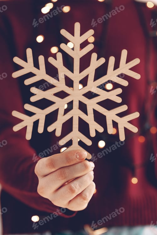 Preview: Female hands holding wooden snowflake, christmas decoration