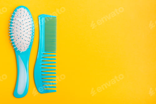 Preview: A set of plastic blue combs on a yellow background. Top view