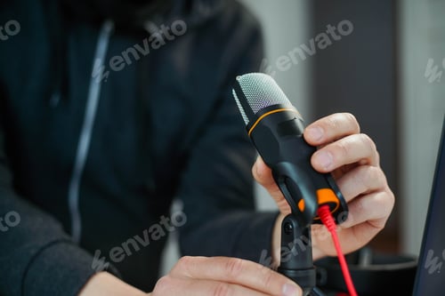 Preview: Closeup hand of young man podcast creator or radio host taking microphone