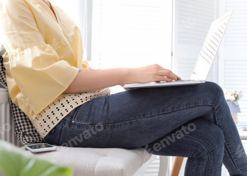 Preview: Young woman working with laptop at home