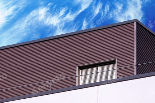 Preview: Industrial building exterior detail against blue cloudy sky, modern abstract geometric architecture