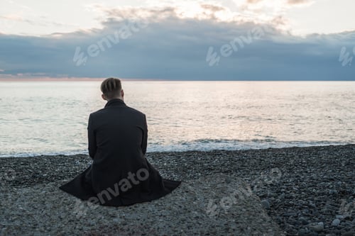 Preview: Lonely man sits by the sea and thinks about something.