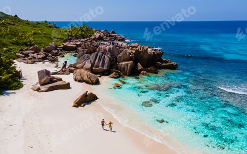 Preview: Anse Cocos La Digue Seychelles, a young couple of men and women on a tropical beach during vacation