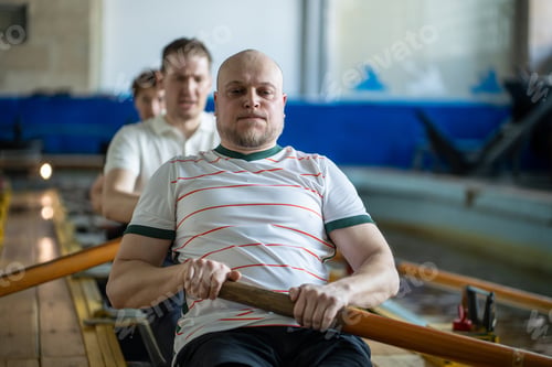 Preview: Focused forced rowing athletes train intensely on rowing simulator during synchronized team workout