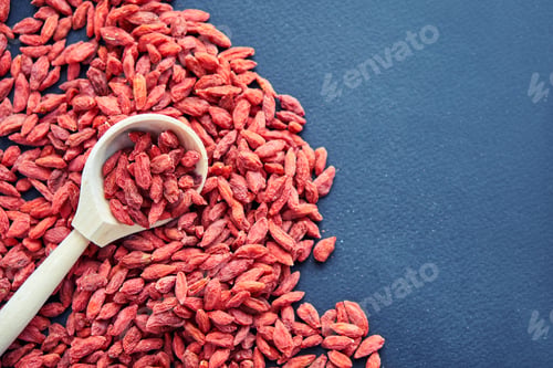 Preview: Goji in bowl on wood table. Top view of fresh goji in scoop and bowl. Goji in heart shape on table.