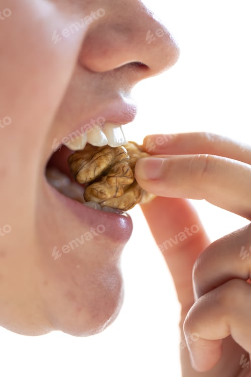 Preview: Detailed shot of a woman bites walnut.