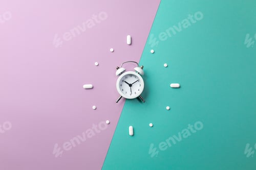 Preview: Pills, tablets and white alarm clock on colorful background. Medical and health concept