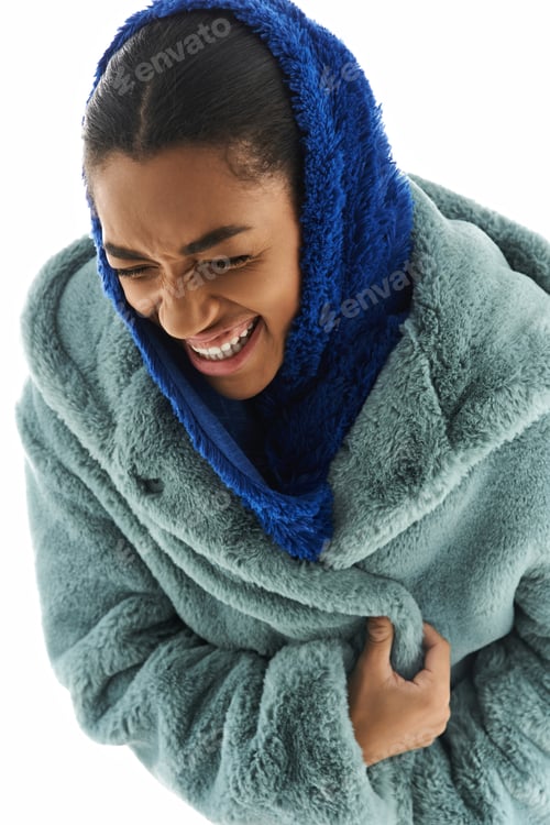 Preview: Joyful young woman in cozy attire radiates warmth and style in a chic setting