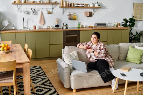 Preview: A young plus sized woman enjoys a refreshing drink while lounging on a stylish sofa.
